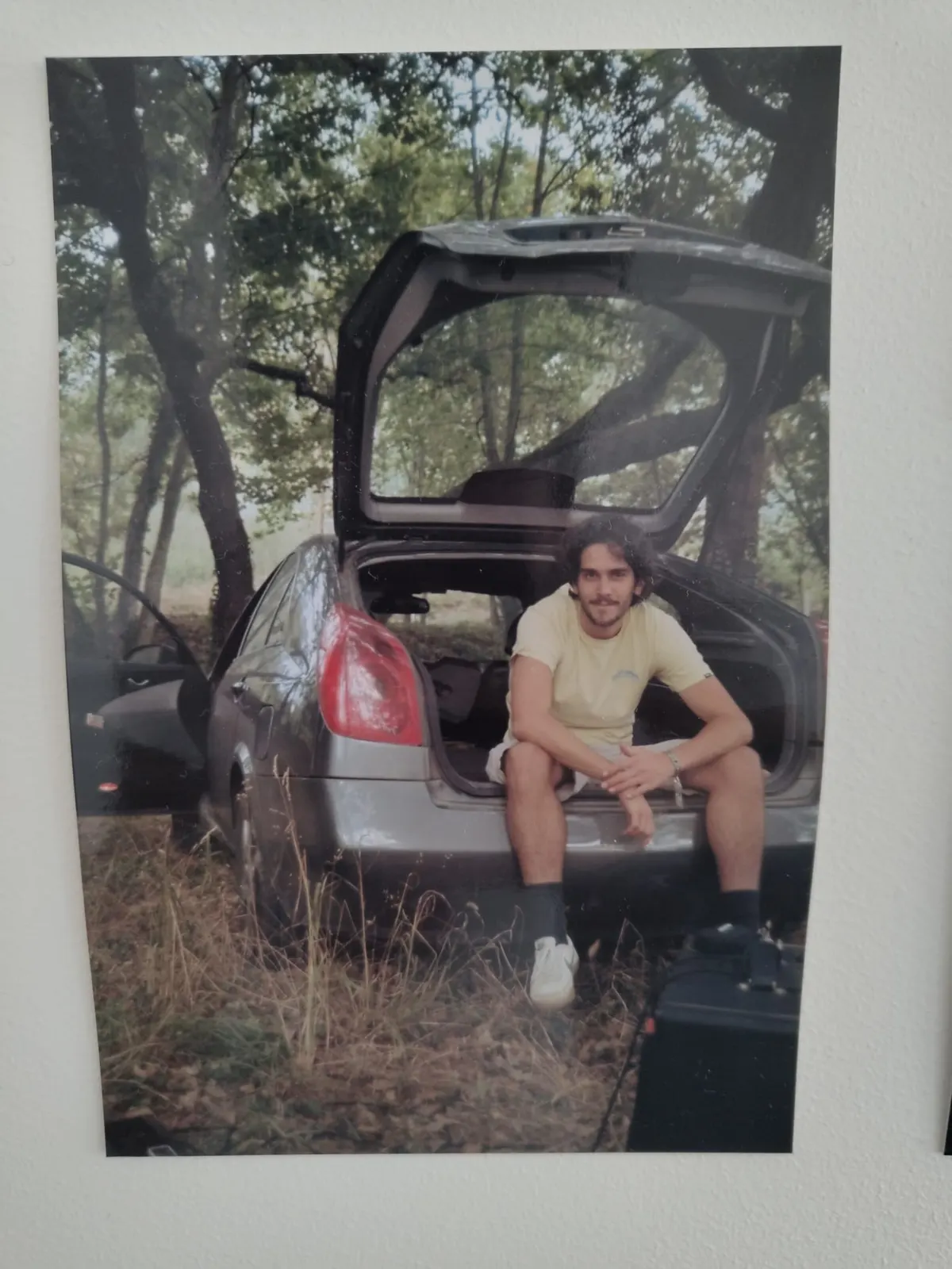 Sadhäna band member sitting in a car trunk during a countryside road trip
