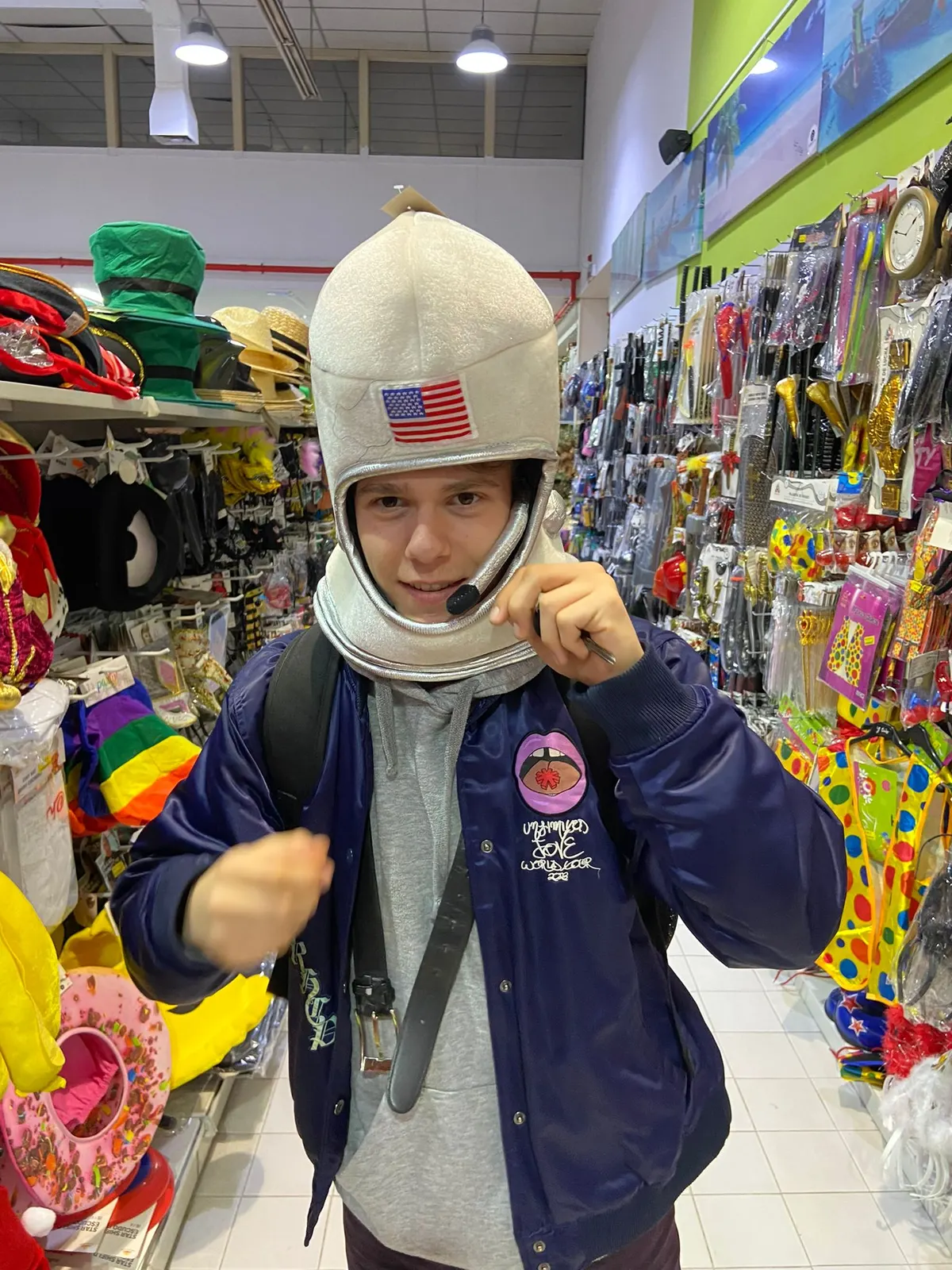 Sadhäna band member trying on a toy astronaut helmet in a costume shop