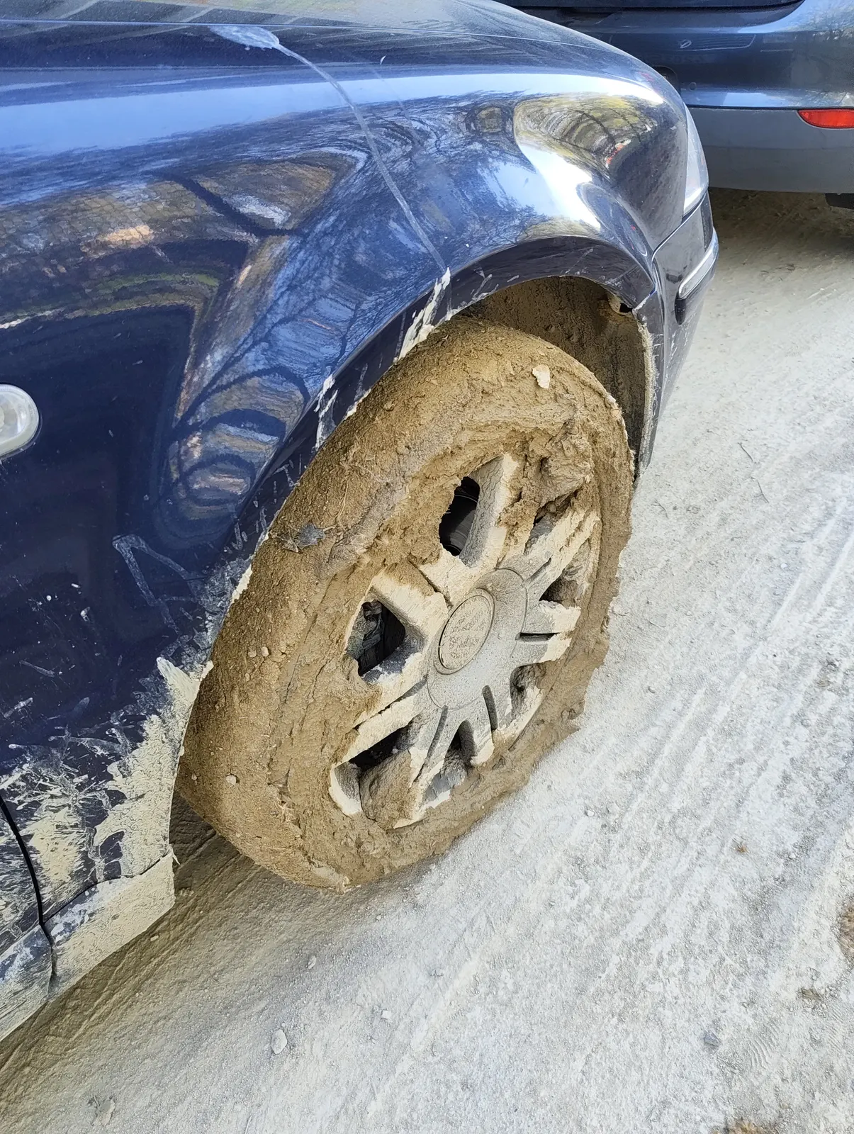 Close-up of a car wheel caked in mud after an off-road adventure