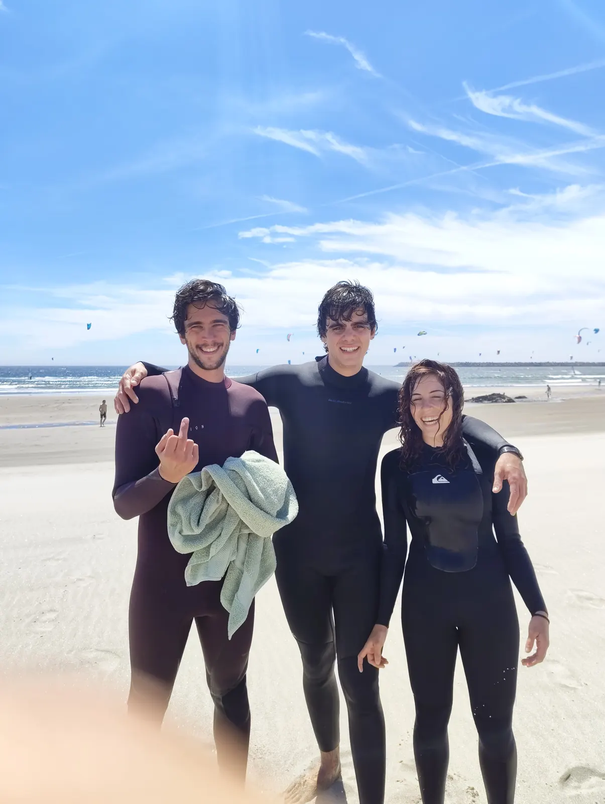 Sadhäna band member with friends in wetsuits at the beach after a surf session