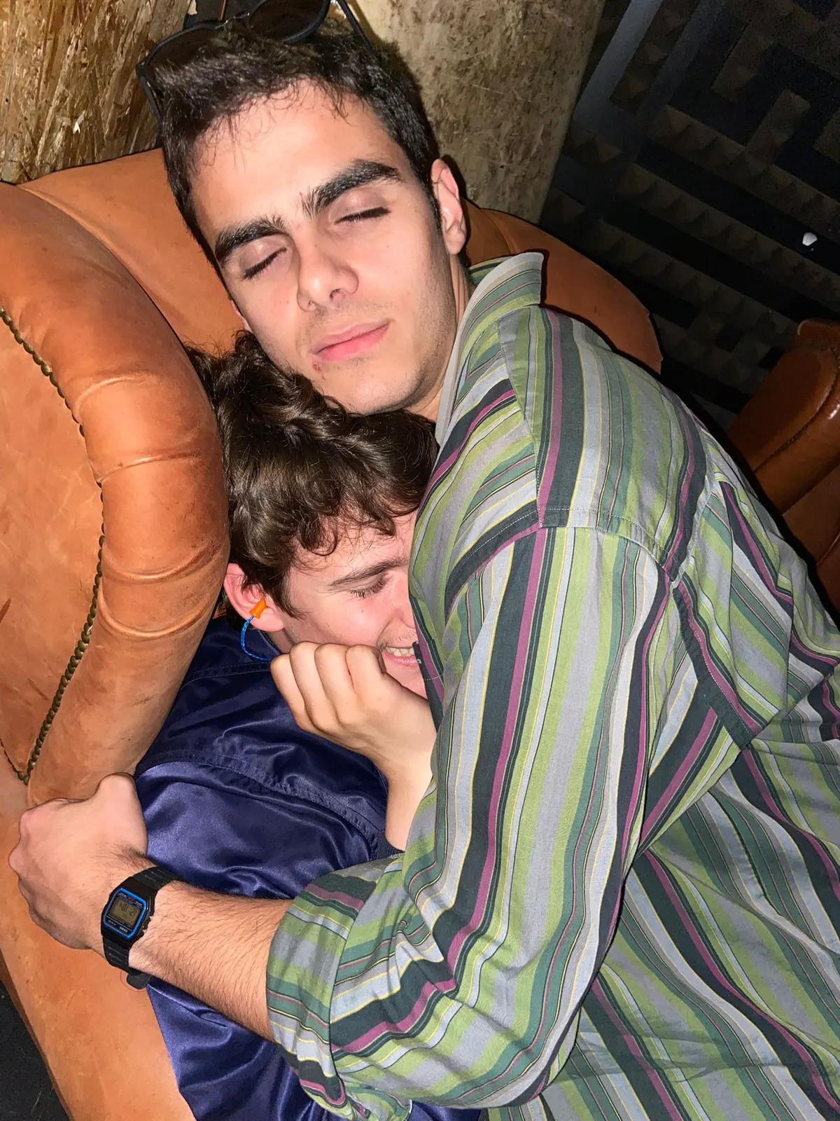 Two Sadhäna band members asleep together on a couch after a long night